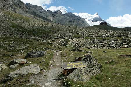 Path rising through rocky terrain towards Fluhalp and the Findel glacier.